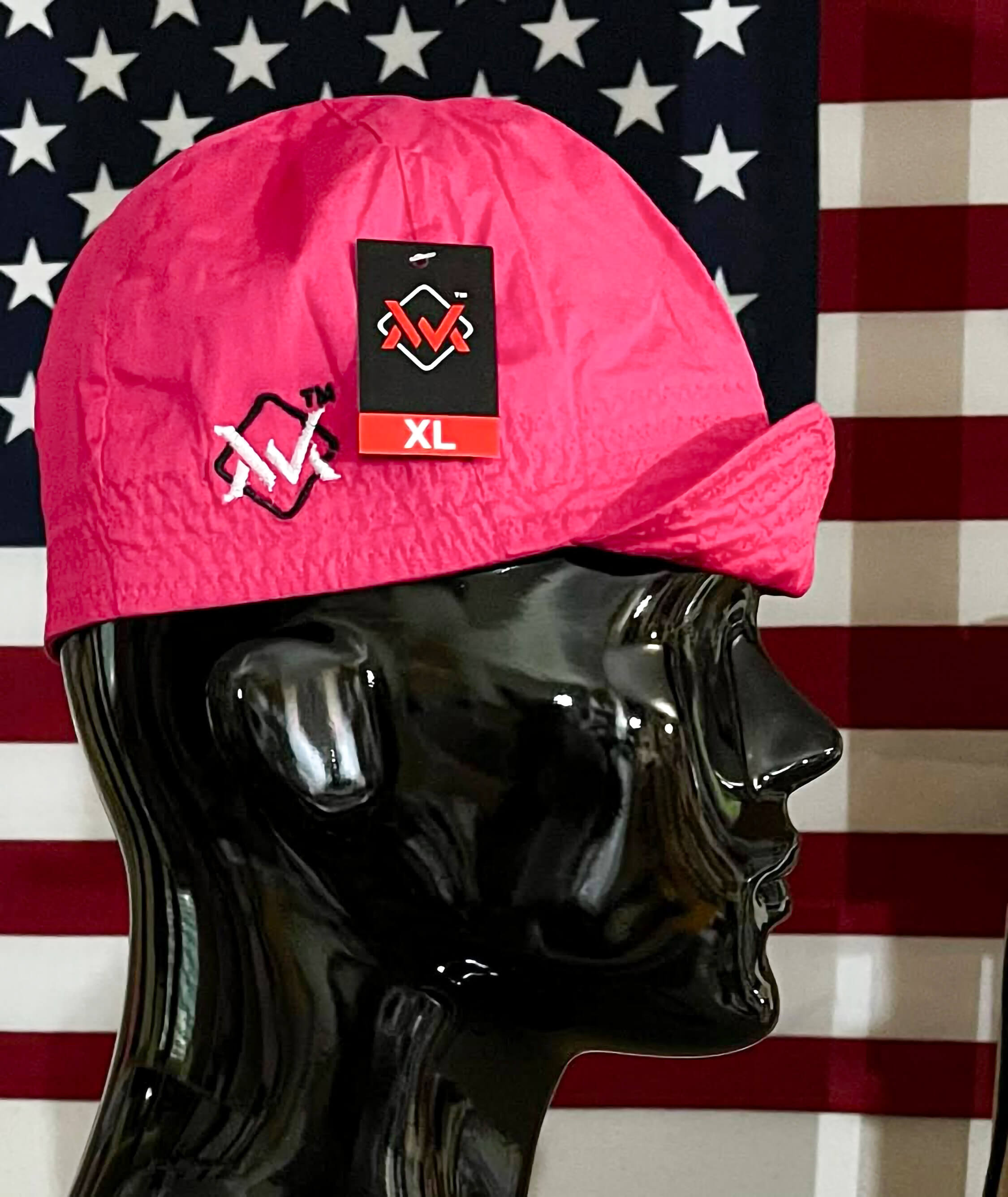 Pink cap with a logo on a black mannequin head against an American flag background