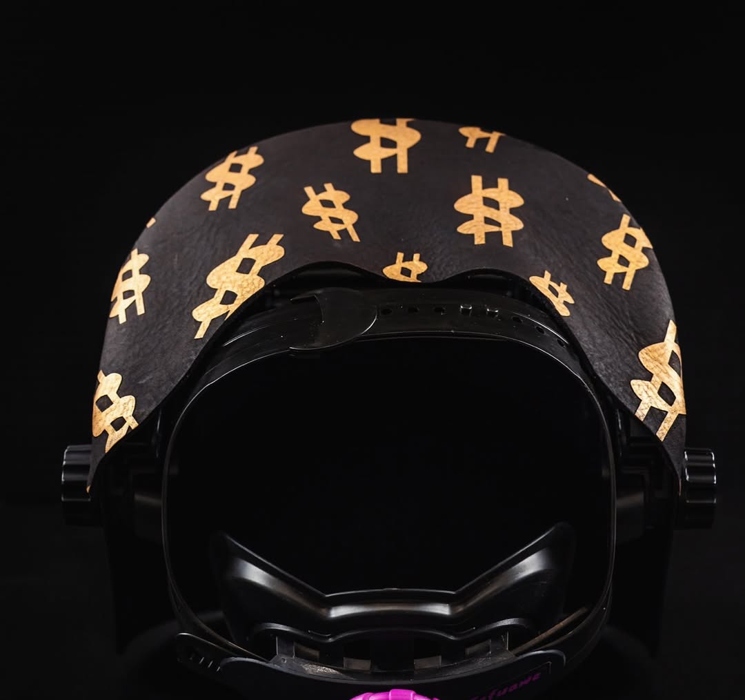 Black helmet with gold dollar sign pattern on a black background