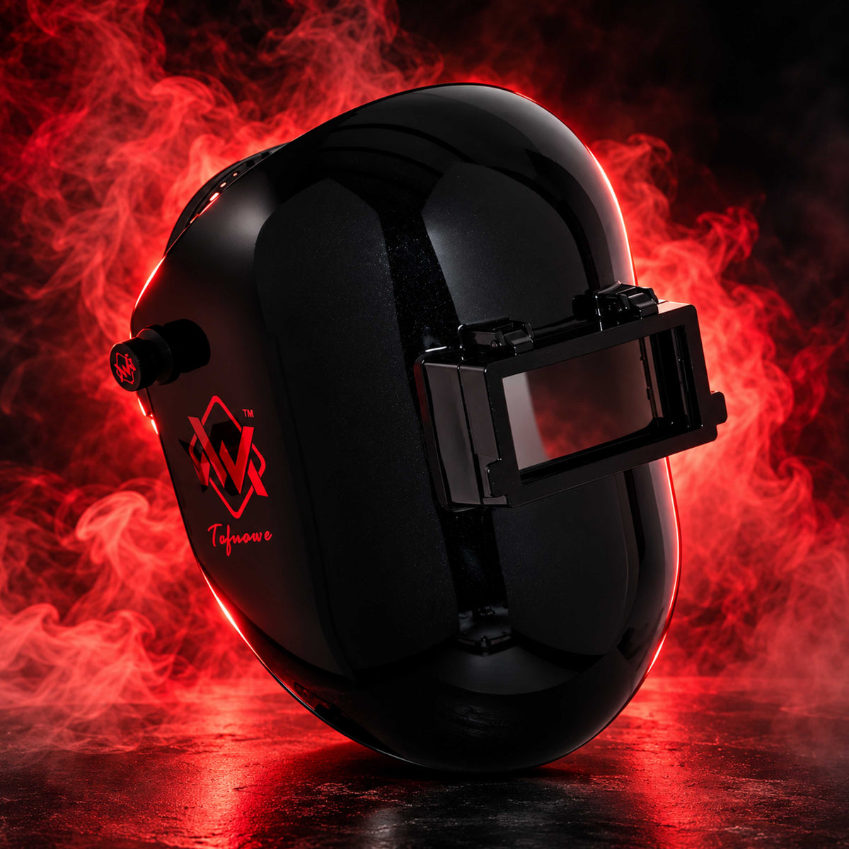 BlazeShield Flip Lens Welding Hood in black, three-quarter view with red smoke background and dramatic studio lighting.