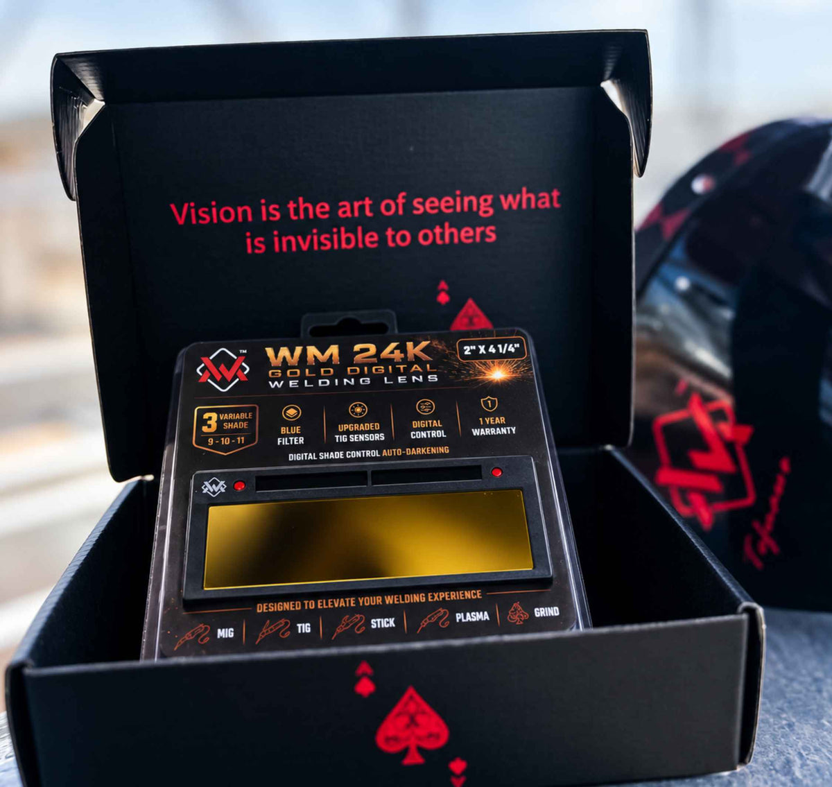 WM 24K Gold Digital Welding Lens displayed in its open branded black box with gold viewing filter and product packaging.