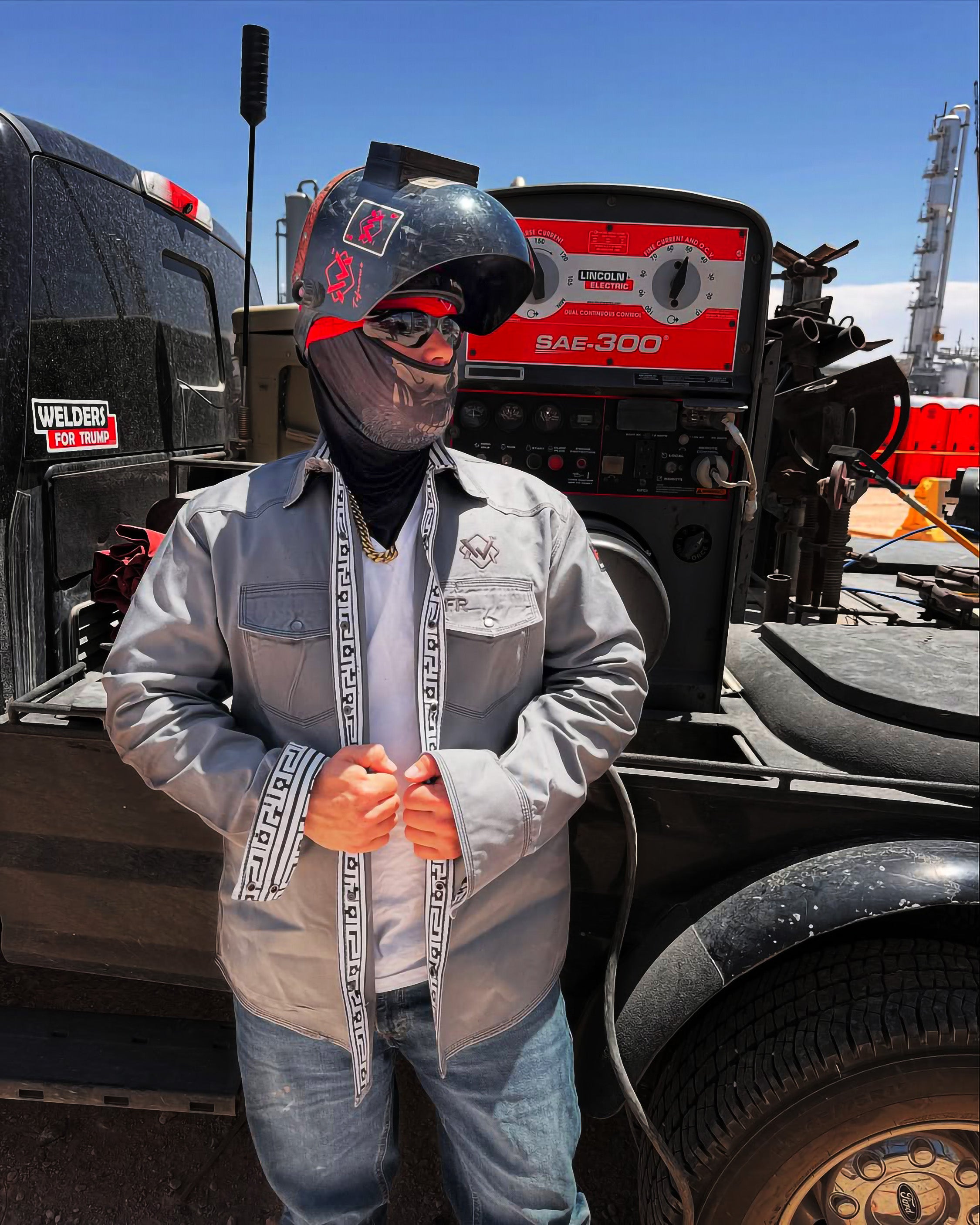 Person wearing a helmet and protective gear standing in front of heavy machinery