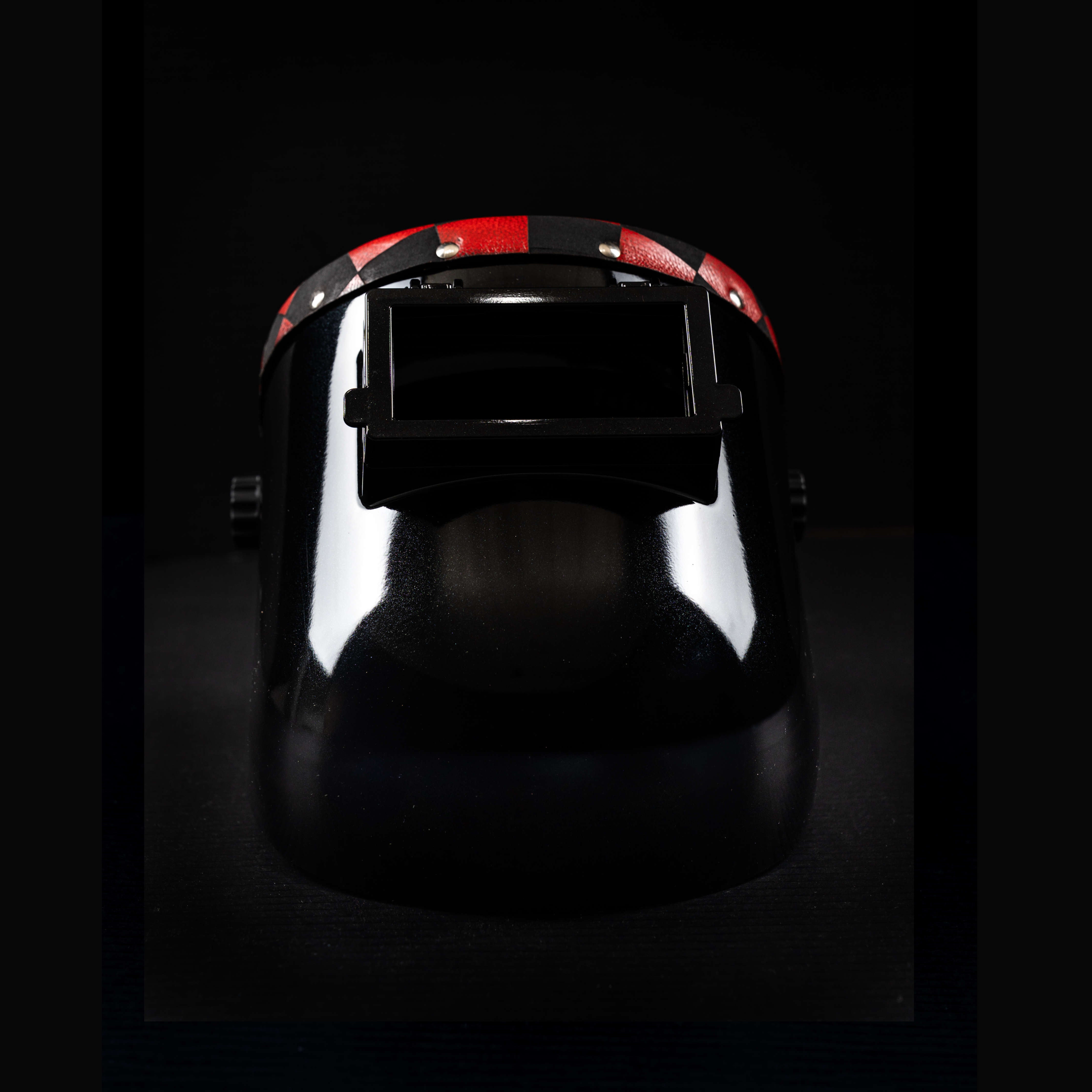 Front view of EliteWave Welding Hood with red and black checkered leather accent and flip lens.