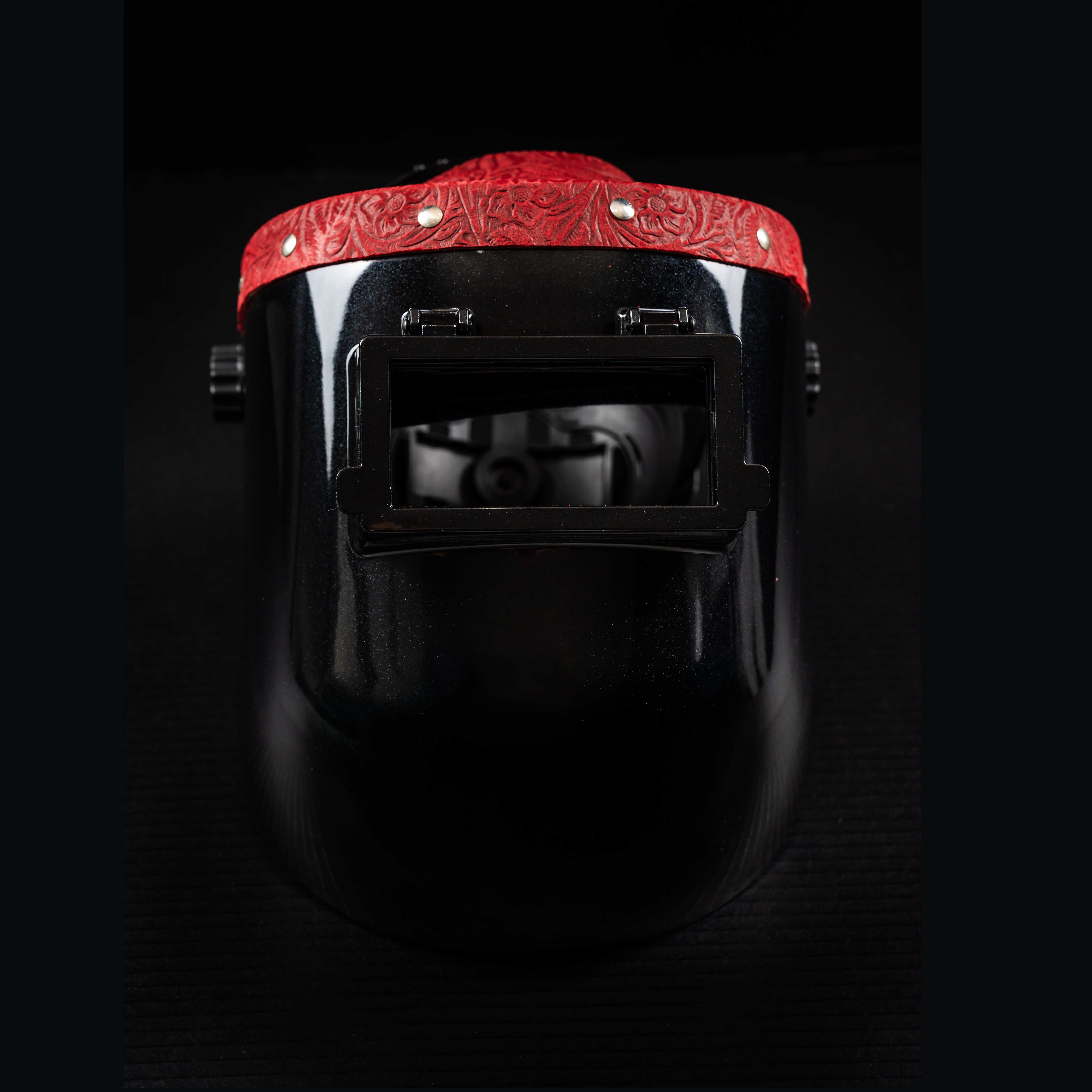Front view of EliteWave Welding Hood featuring red floral leather accent and open lens window.