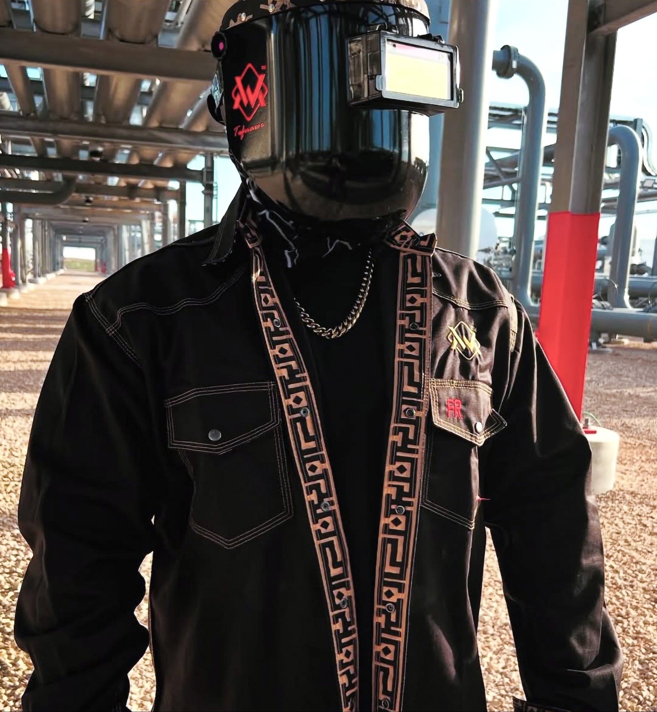 Person wearing a gold aztec shirt with decorative elements in an industrial setting
