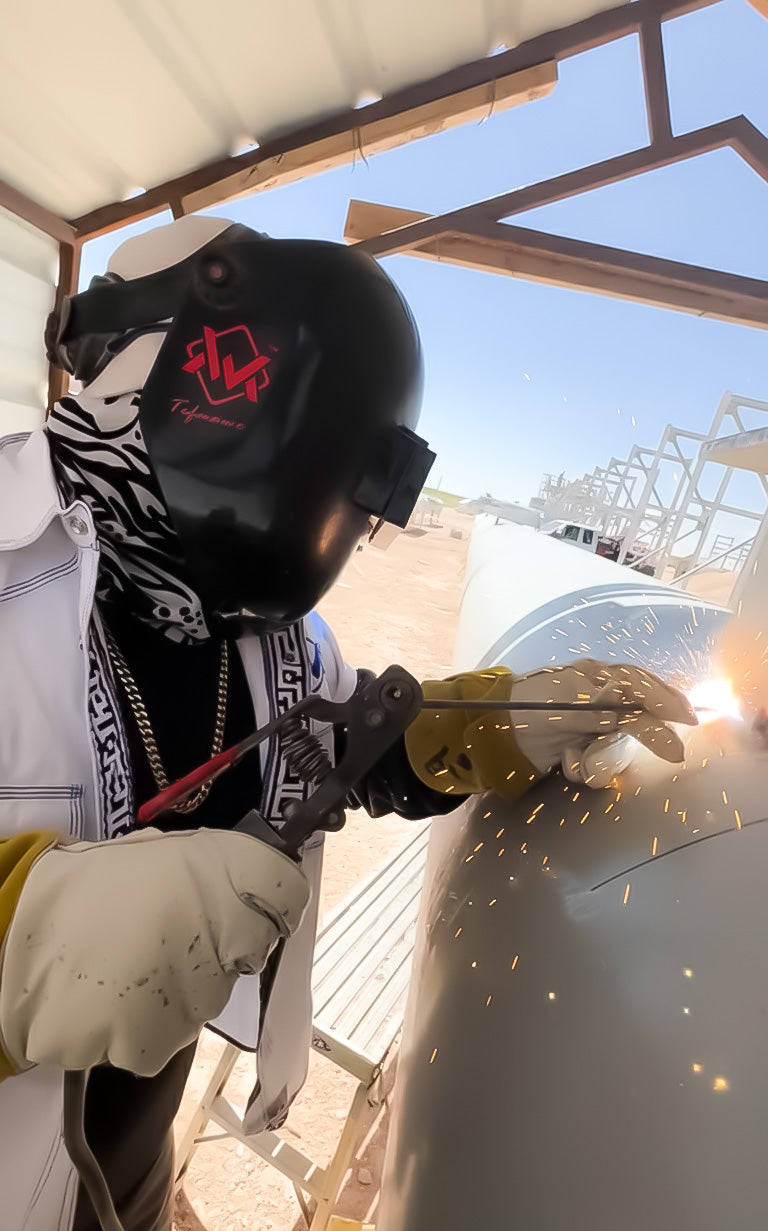 Person welding a metal surface with protective gear on.