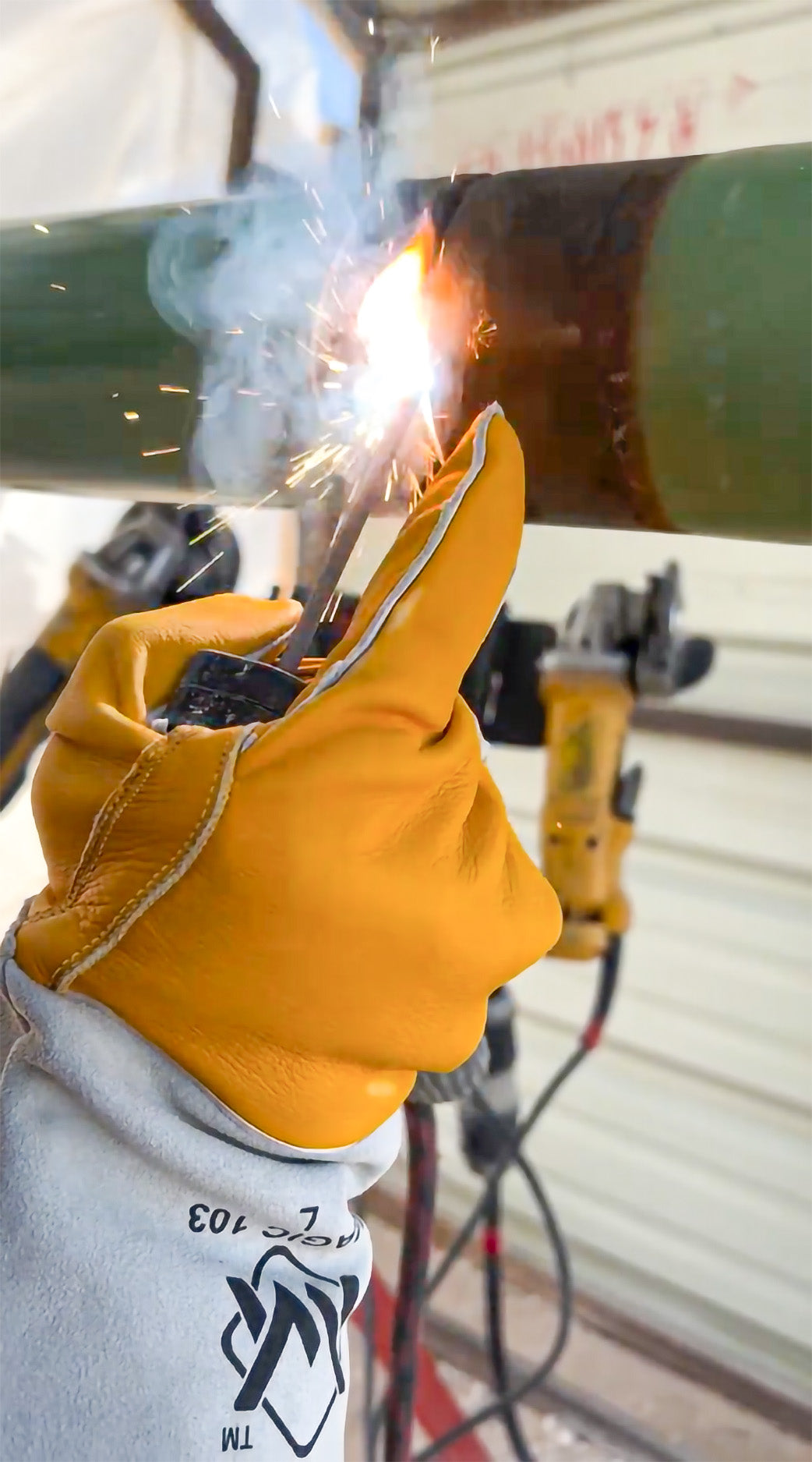 Person welding with sparks and protective gear in a workshop setting